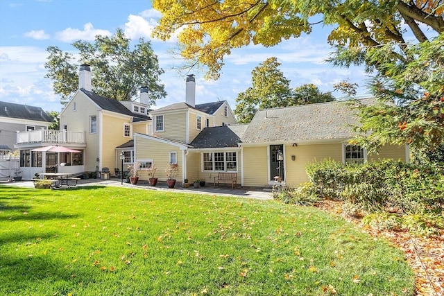 back of house with a patio area and a yard