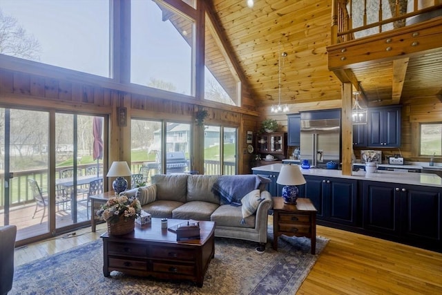 living area with wood walls, beam ceiling, high vaulted ceiling, light wood-type flooring, and wood ceiling