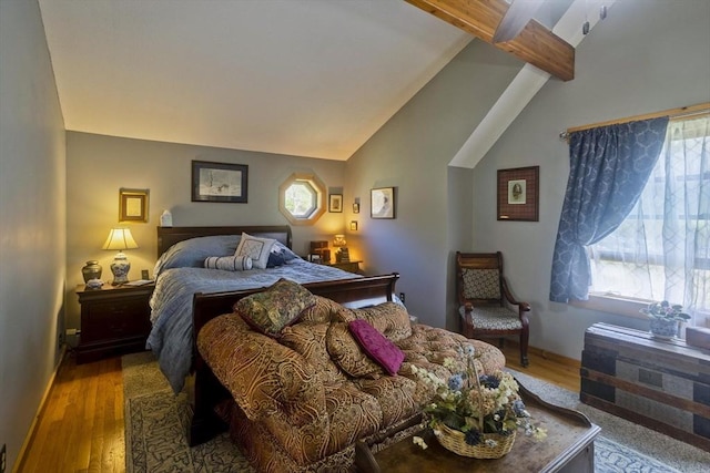 bedroom featuring vaulted ceiling with beams and wood finished floors