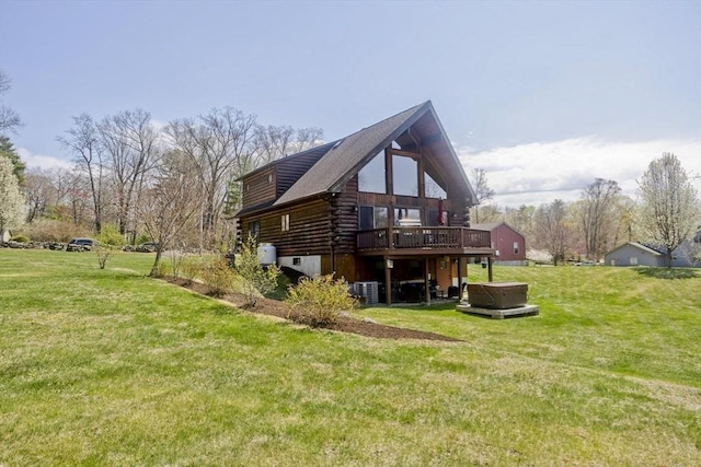 view of side of home with log siding, central air condition unit, a hot tub, a deck, and a lawn