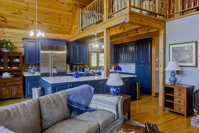 living room featuring wood walls, a toaster, high vaulted ceiling, wooden ceiling, and light wood finished floors
