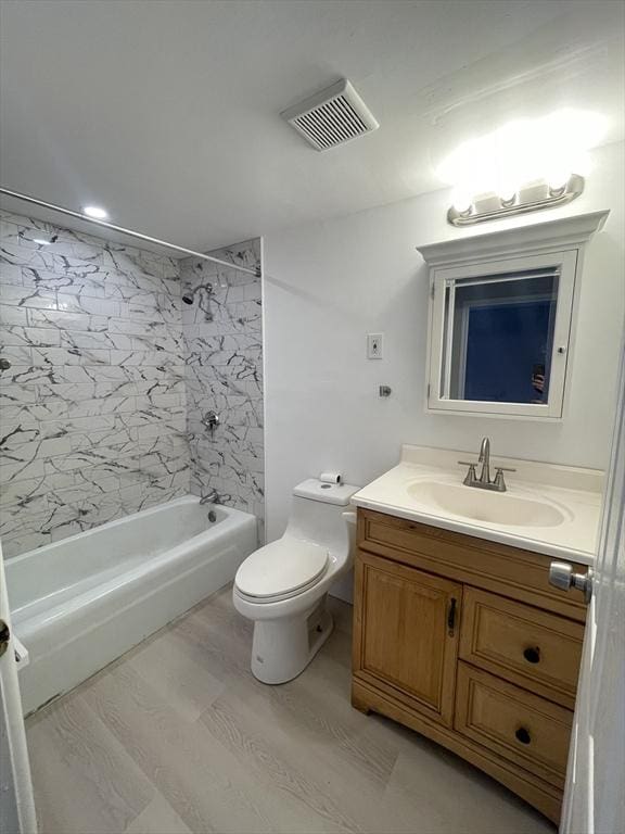 full bathroom featuring vanity, toilet, tiled shower / bath combo, and wood-type flooring