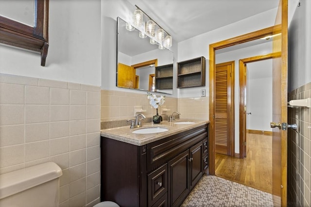 bathroom with tile walls, vanity, tile patterned flooring, and toilet