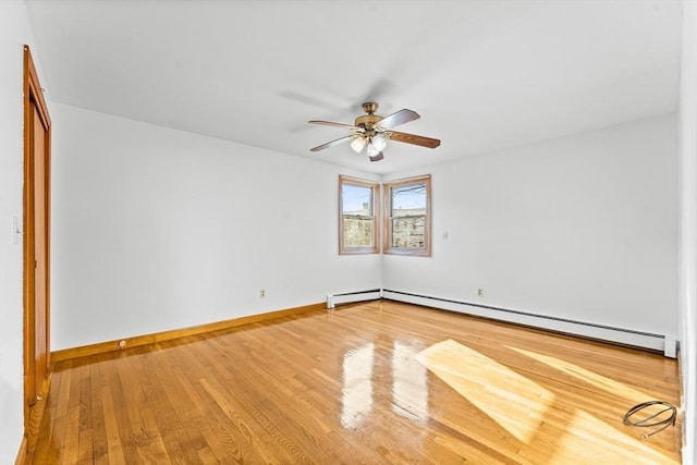 unfurnished room with ceiling fan, hardwood / wood-style floors, and a baseboard heating unit