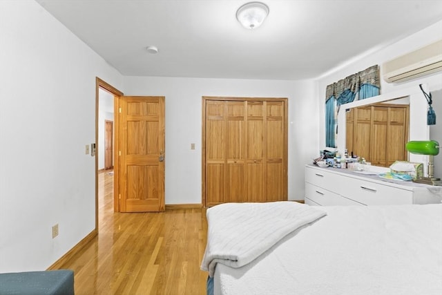 bedroom featuring a wall mounted AC and light wood-type flooring