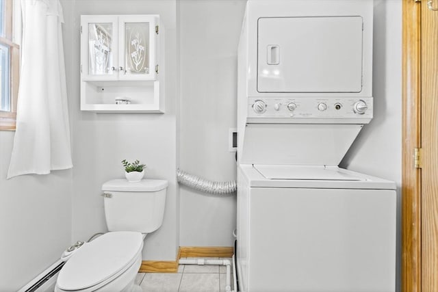 bathroom featuring stacked washer and dryer, tile patterned floors, toilet, and baseboard heating