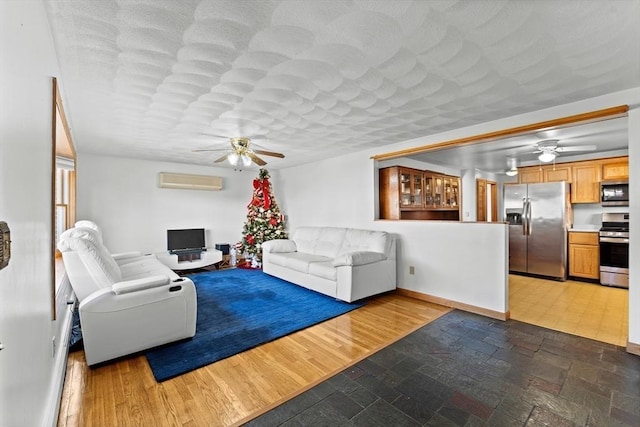 living room featuring dark wood-type flooring, a wall mounted AC, and ceiling fan