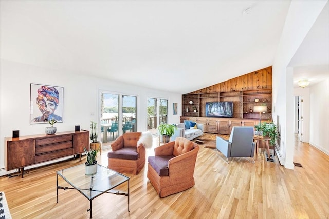 living room with lofted ceiling, a baseboard heating unit, and light wood-type flooring