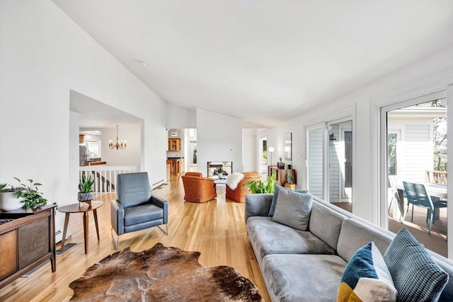 living room featuring an inviting chandelier, wood-type flooring, and a healthy amount of sunlight