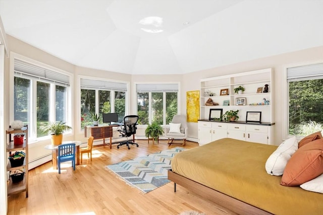 bedroom with light hardwood / wood-style flooring, a baseboard radiator, and high vaulted ceiling