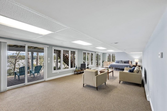 living room with plenty of natural light, light carpet, and a drop ceiling