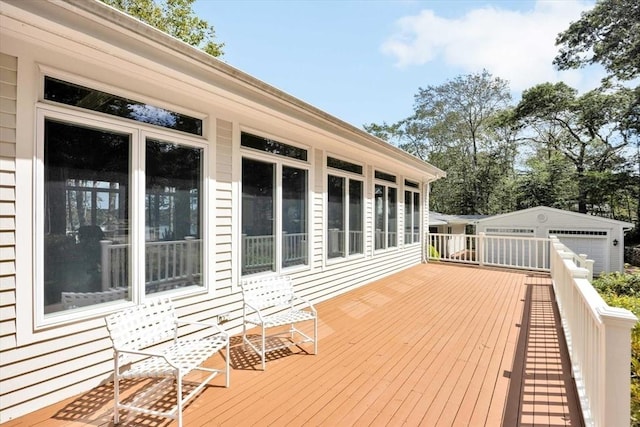 wooden terrace featuring a garage and an outdoor structure