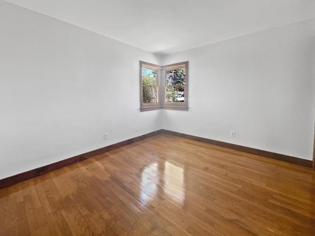spare room featuring baseboards and hardwood / wood-style floors