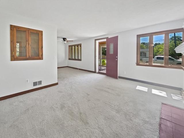 unfurnished living room with visible vents, carpet flooring, baseboards, and a ceiling fan