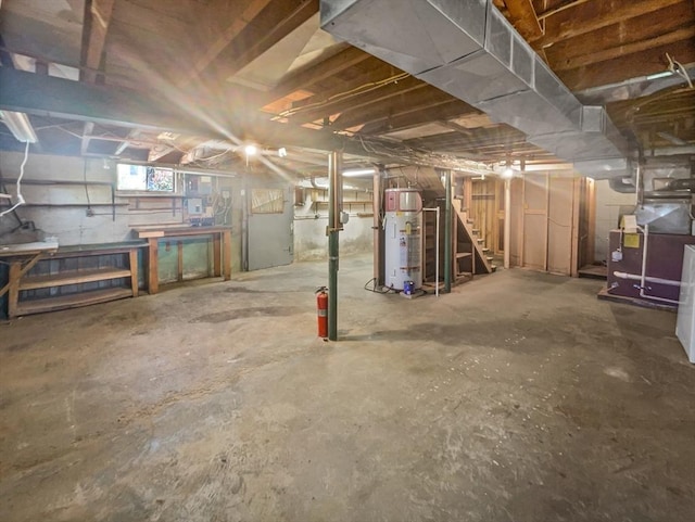basement with stairway, heating unit, a workshop area, and water heater