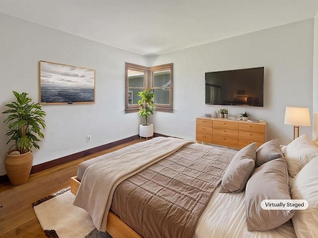 bedroom featuring baseboards and wood finished floors