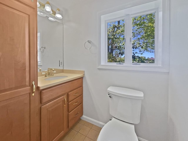 half bathroom featuring baseboards, tile patterned floors, toilet, and vanity