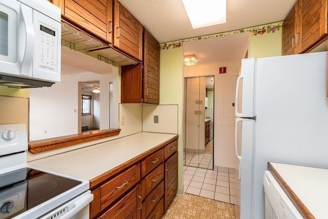 200 Burkhall Unit 103, Weymouth, MA 02190 - kitchen with white appliances, light countertops, brown cabinetry, light tile patterned flooring, and ceiling fan