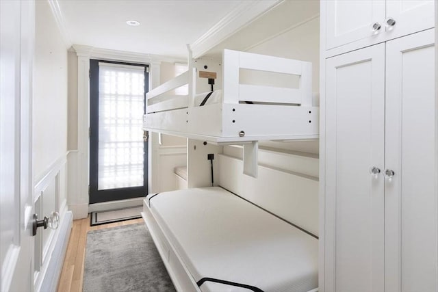 bedroom with crown molding and light hardwood / wood-style flooring