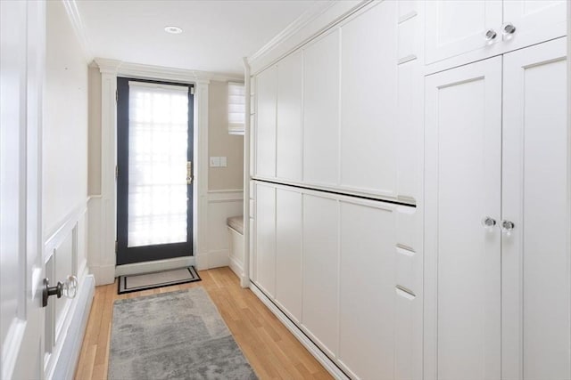 doorway to outside featuring crown molding and light hardwood / wood-style flooring