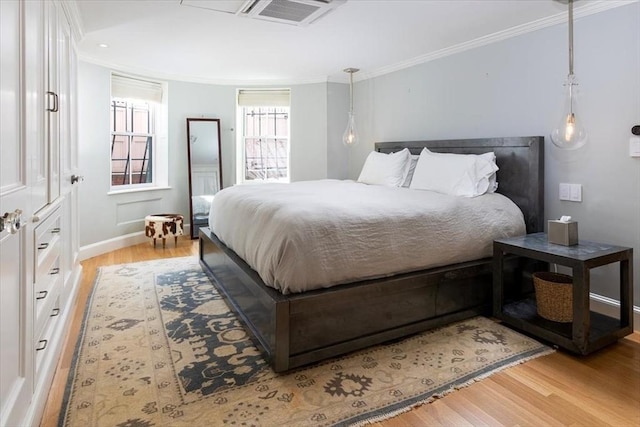 bedroom with crown molding and light hardwood / wood-style flooring