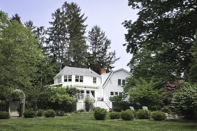 14 Dodges Row, Wenham, MA 01984 - back of property featuring a lawn, stairway, a chimney, and a wooden deck