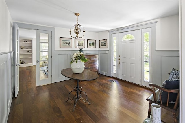 14 Dodges Row, Wenham, MA 01984 - foyer entrance featuring dark wood-type flooring, plenty of natural light, a chandelier, a decorative wall, and a wainscoted wall