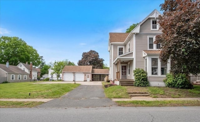 14 Maple St, Amesbury, MA 01913 - view of front of home with a detached garage, a front lawn, and roof with shingles