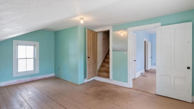 14 Maple St, Amesbury, MA 01913 - additional living space featuring light wood-type flooring, stairway, baseboards, and lofted ceiling