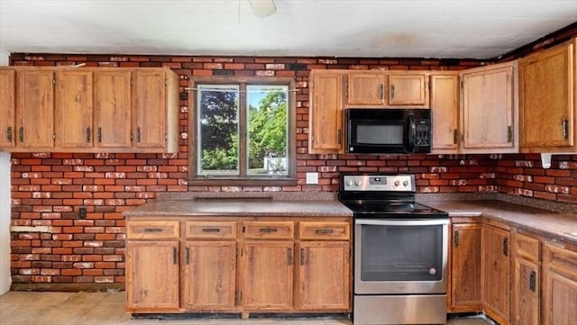 14 Maple St, Amesbury, MA 01913 - kitchen with black microwave, stainless steel range with electric cooktop, light tile patterned floors, and brown cabinets