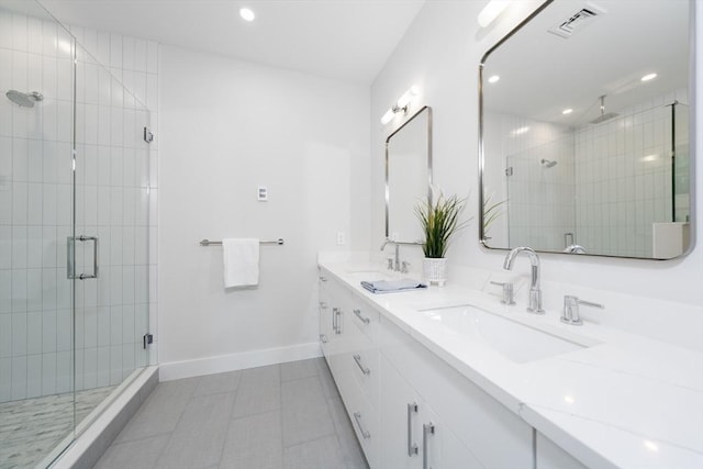 bathroom with tile patterned flooring, vanity, and walk in shower