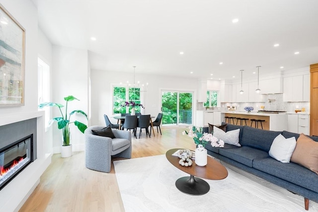 living room with a notable chandelier and light hardwood / wood-style flooring