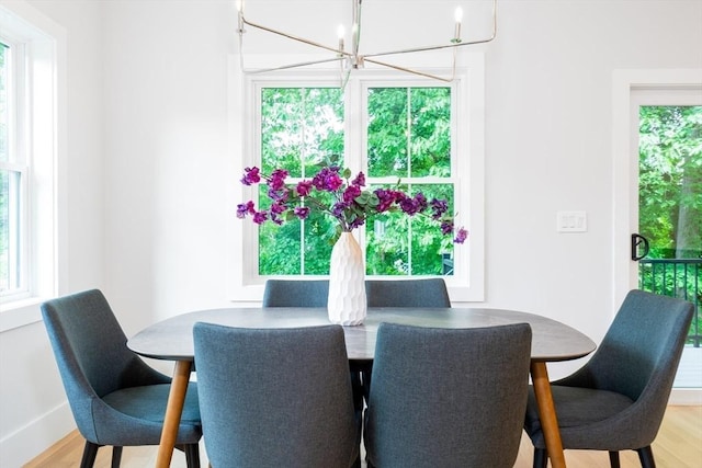 dining space featuring light hardwood / wood-style flooring and an inviting chandelier