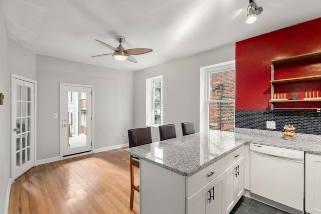 159 Cottage St Unit 6, Boston, MA 02128 - kitchen featuring white dishwasher, a peninsula, a ceiling fan, white cabinets, and backsplash