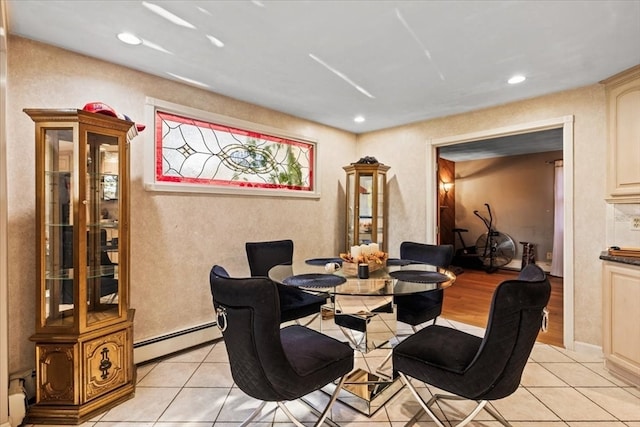 dining area with a baseboard heating unit and light wood-type flooring