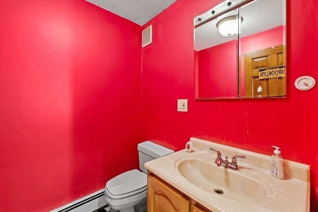 bathroom featuring toilet, a baseboard heating unit, and vanity