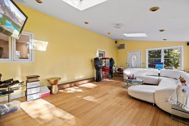 living room with vaulted ceiling with skylight and light hardwood / wood-style floors