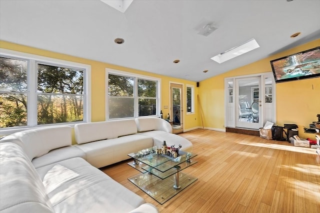 living room with light hardwood / wood-style flooring and lofted ceiling with skylight