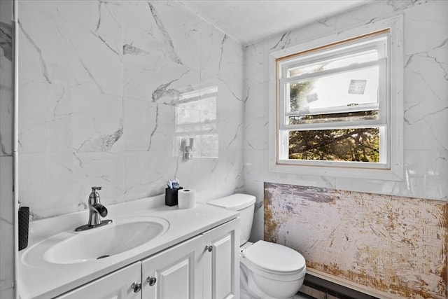 bathroom with tile walls, vanity, toilet, and a baseboard radiator