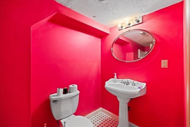 bathroom featuring toilet and a textured ceiling