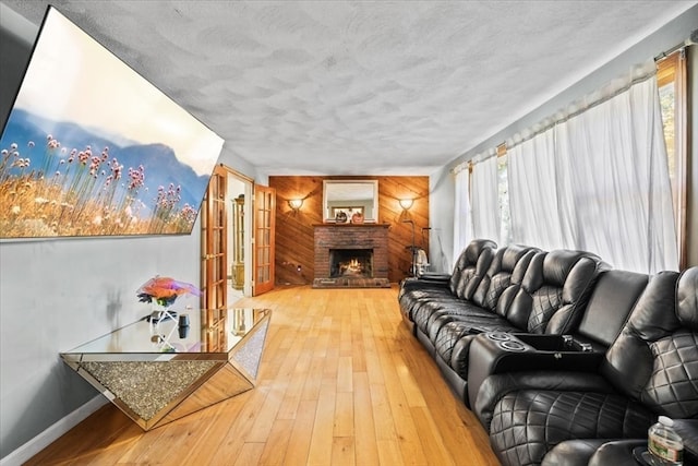 living room featuring a textured ceiling, a wealth of natural light, a fireplace, and hardwood / wood-style floors