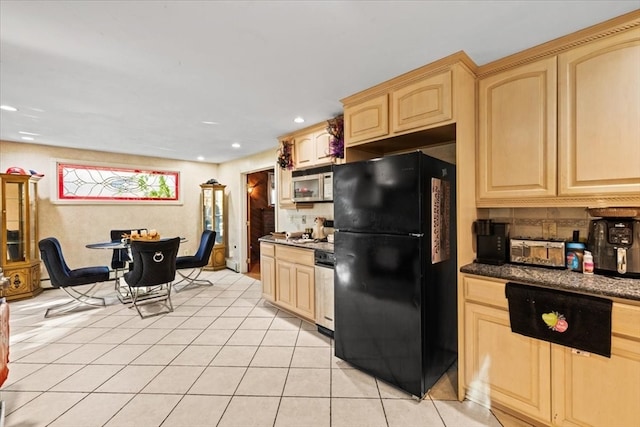 kitchen featuring light tile patterned flooring, stainless steel appliances, light brown cabinetry, and backsplash