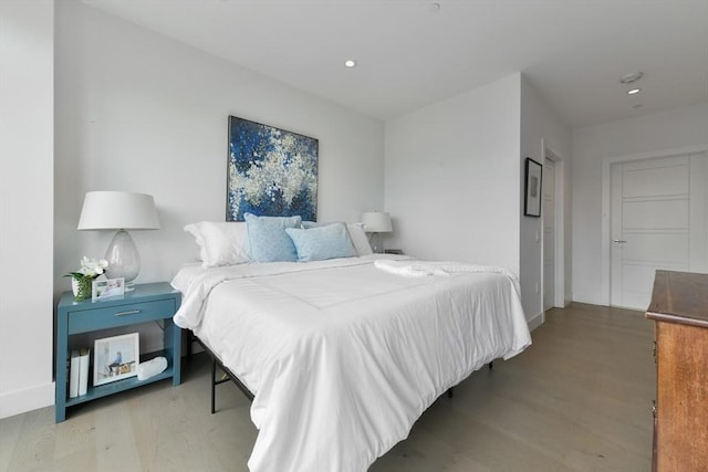 bedroom with wood finished floors, recessed lighting, and baseboards