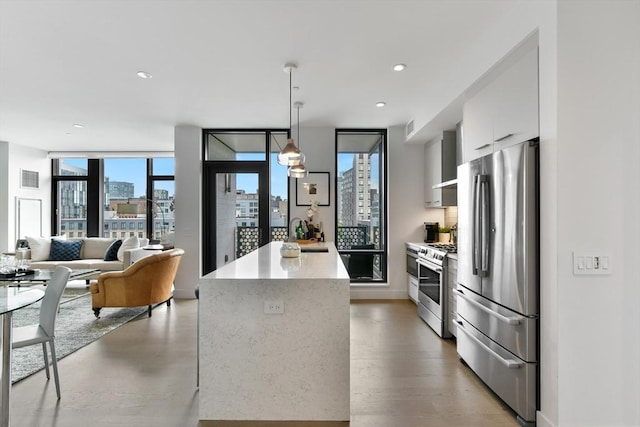 kitchen with stainless steel appliances, modern cabinets, healthy amount of natural light, white cabinets, and recessed lighting