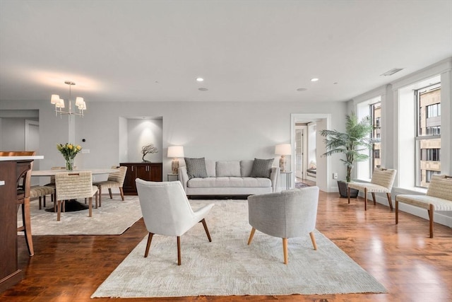 living room featuring recessed lighting, dark wood finished floors, and an inviting chandelier