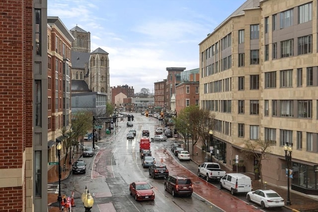 view of road featuring curbs, street lighting, and sidewalks