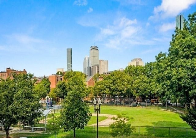 view of community with a view of city, fence, and a yard