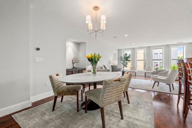 dining space with baseboards, a wealth of natural light, and wood finished floors