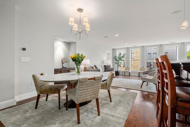 dining room featuring a wealth of natural light, baseboards, a chandelier, and wood finished floors