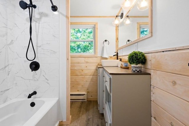 full bath featuring shower / bath combination, vanity, wood finished floors, and a baseboard heating unit